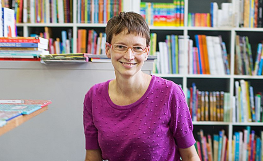 Natalia Wajda, uśmiechnięta kobieta w bardzo krótkich włosach i okularach